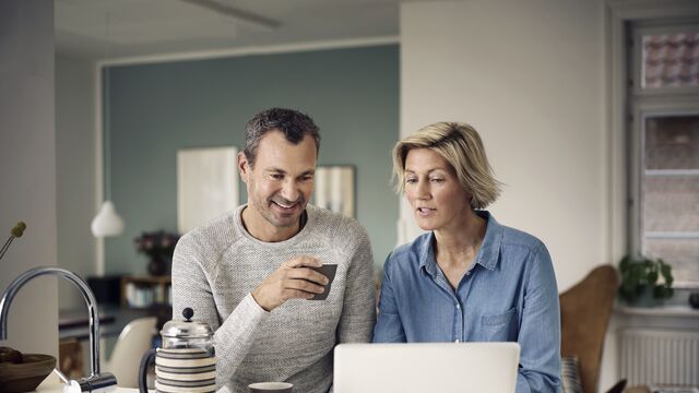 Mann og kvinne som ser på en laptop sammen.